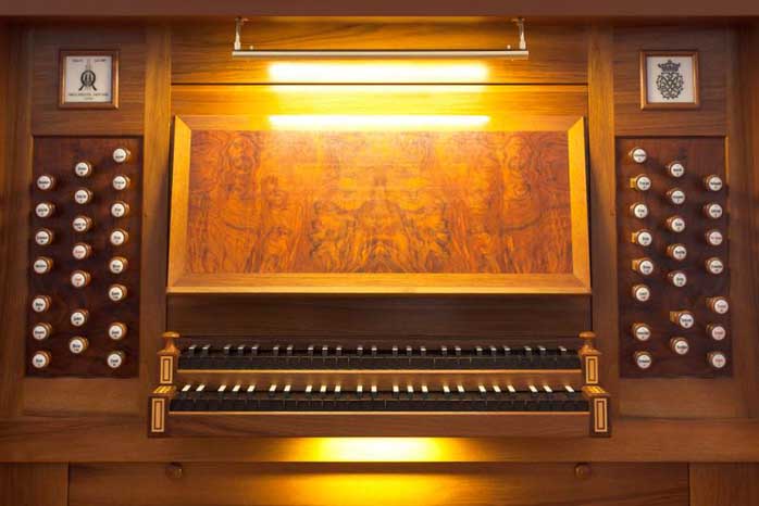 Spieltisch der Orgel in hellbraunem Holz mit zwei Manualen und 44 Registerzügen rechts und links
