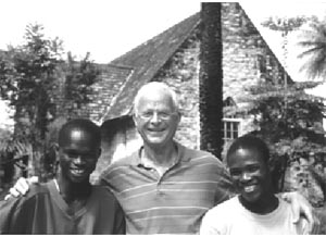 Gerd Kunstmann und zwei junge Afrikaner stehen vor einem Kirchengebäude in Kenia