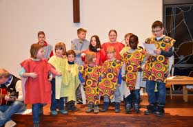 Kinder im Altarraum der EMK Neuenhain in bunten Kleidern für die Zachäus-Geschichte