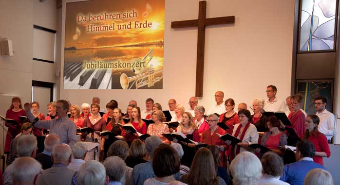 Die 34 Sängerinnen und Sänger des Gemischten Chores stehen im Altarraum und singen
