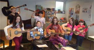 Fünf Mädchen und zwei Jungen mit ihren Gitarren