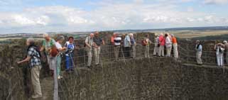 Siebzehn Teilnehmer am Ausflug in die Wetterau stehen an der Burgmauer der Münzenberg und genießen den herrlichen Ausblick bei weiß-blauem Himmel